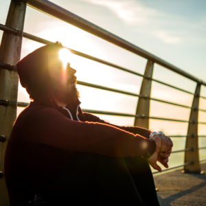 A man sitting in sunlight, representing hope and the journey towards recovery in addictions counselling.